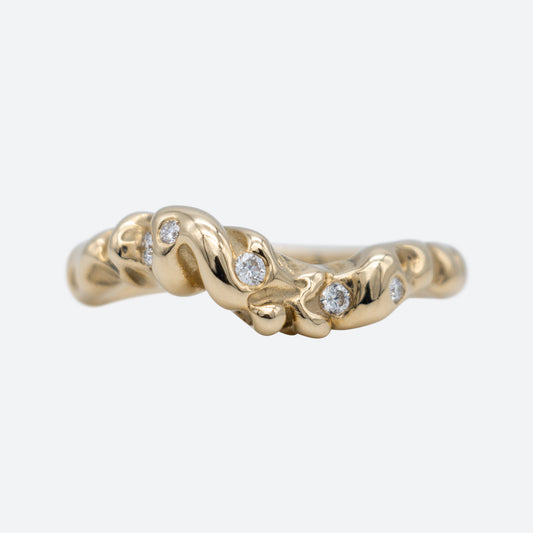 Ring i guld med fem diamanter set forfra på hvid baggrund. Bugter sig som en bølge. Design af Michell Liljefelt