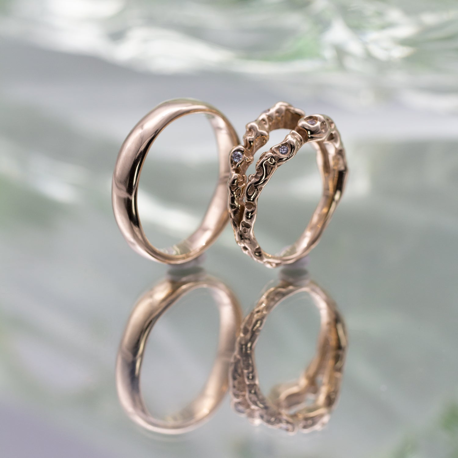 To vielsesringe i genanvendt guld i klassisk og organisk formgivning. Den organiske ring er med fairtrade diamanter og ringskinnen splitter op og forenes igen. 