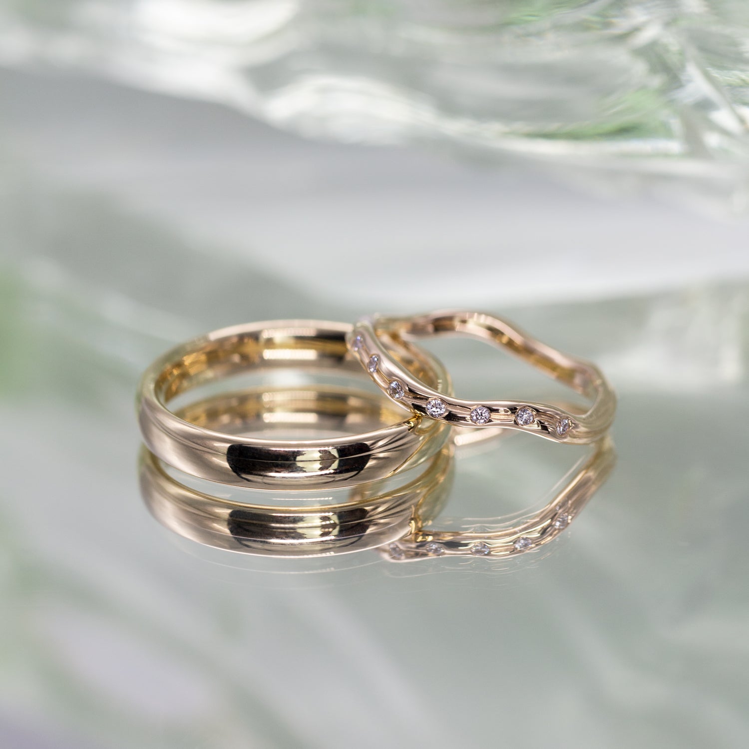 To vielsesringe i genanvendt guld i klassisk og organisk formgivning. Den organiske ring er med fairtrade diamanter. 