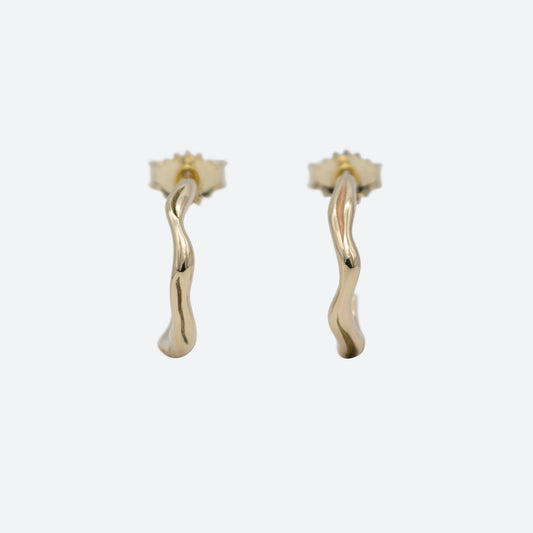 To øreringe hoops i guld set forfra på hvid baggrund. Begge er formgivet som creoler og med lås i guld. Design af Michell Liljefelt