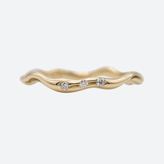 Smal ring i guld set forfra med tre diamanter på hvid baggrund. Design af Michell Liljefelt
